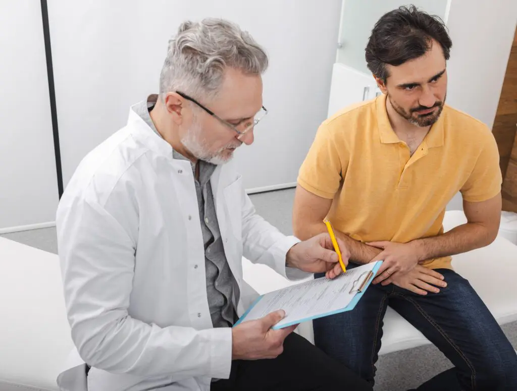 Urologist consultation for male patient with male doctor, looking over paperwork