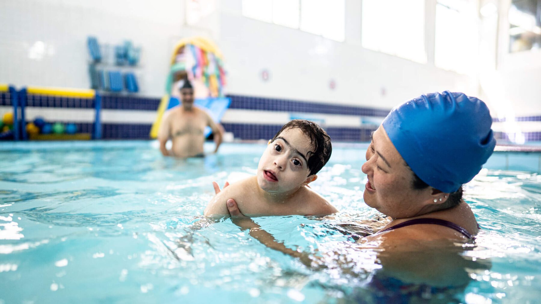 Instructor and boy with down syndrome on a swimming lesson