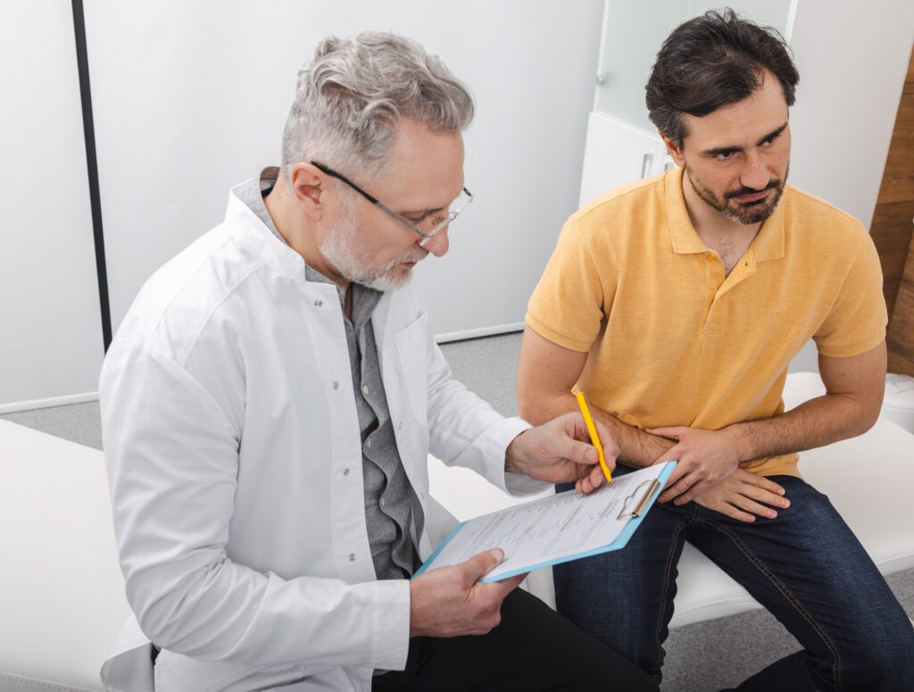Urologist consultation for male patient with male doctor, looking over paperwork
