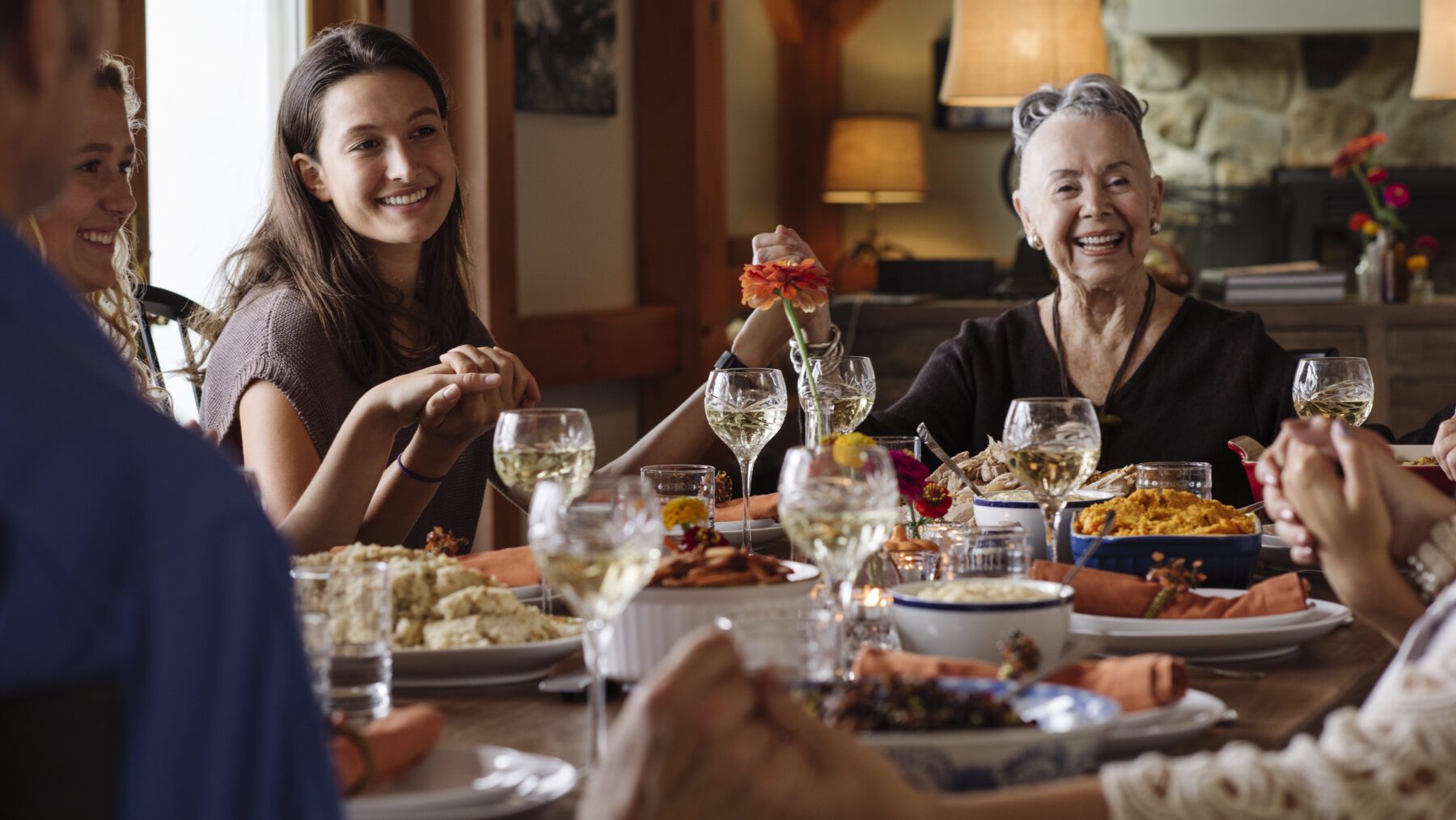 Happy family holding hands during Thanksgiving at home.