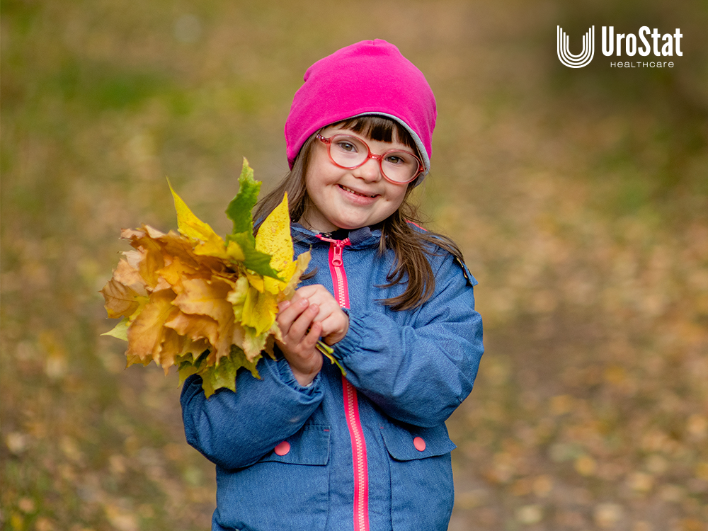 Little girl holding pile of leaves while standing outside