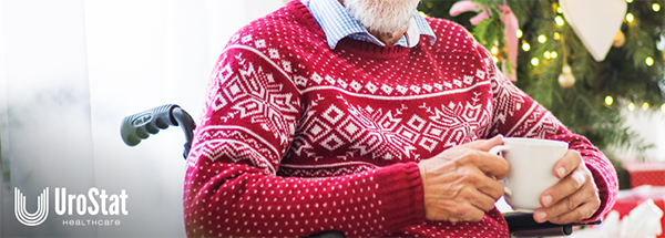 Older man in holiday sweater in a wheelchair, drinking coffee during holiday season