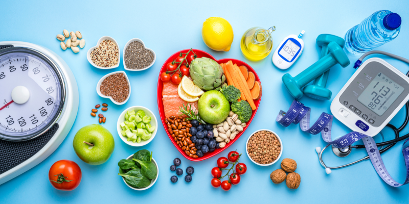 Various healthy foods and glucose meter, weights, blood pressure machine, water bottle, weights, scale