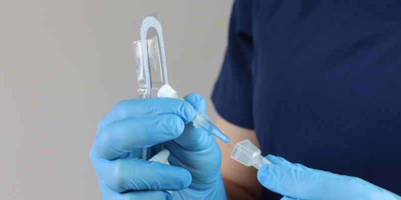 Healthcare professional wearing gloves manipulating the peripheral catheter pack