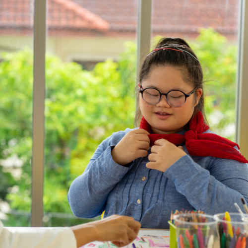 Girl with autism looking at artwork in school with her teacher