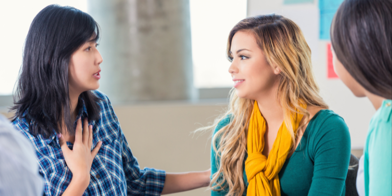 Three women speaking at support group together