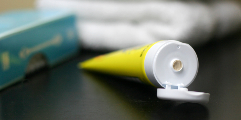Yellow diaper rash cream tube with aqua q-tip box and white towels