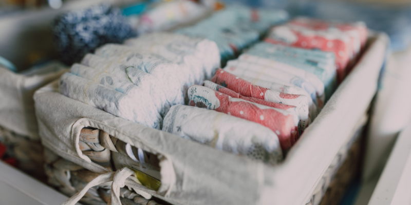 Two rows of diapers in a wicker basket on table