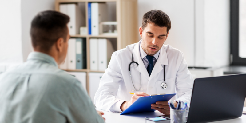 Man speaking with male doctor in his office