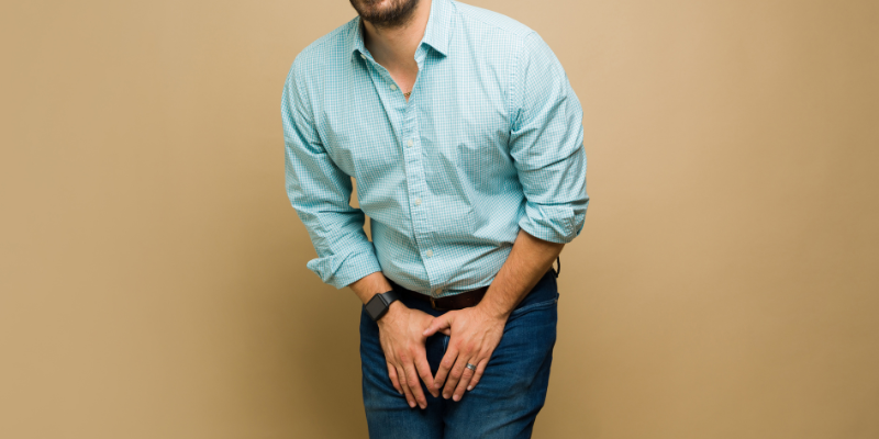 Man with hands in front of lap indicating need to use the bathroom