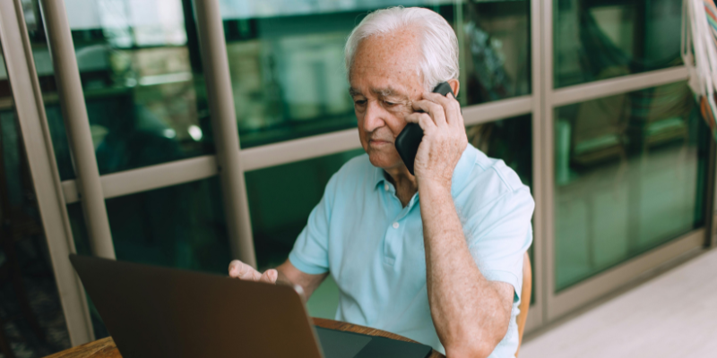 Senior man on the phone using his laptop